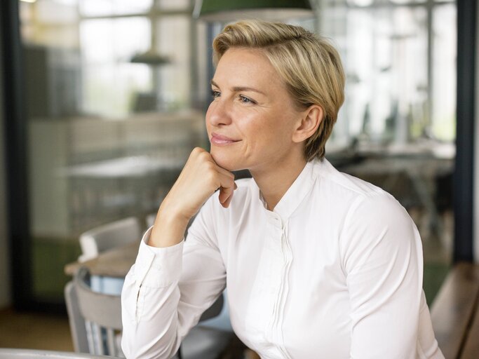 Blonde Businessfrau trägt eine weiße Bluse und hat einen modernen Kurzhaarschnitt. | © imago/Westend61