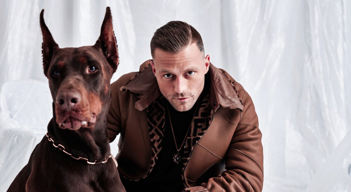 Rapper Kontra K  mit einem Hund an seiner Seite