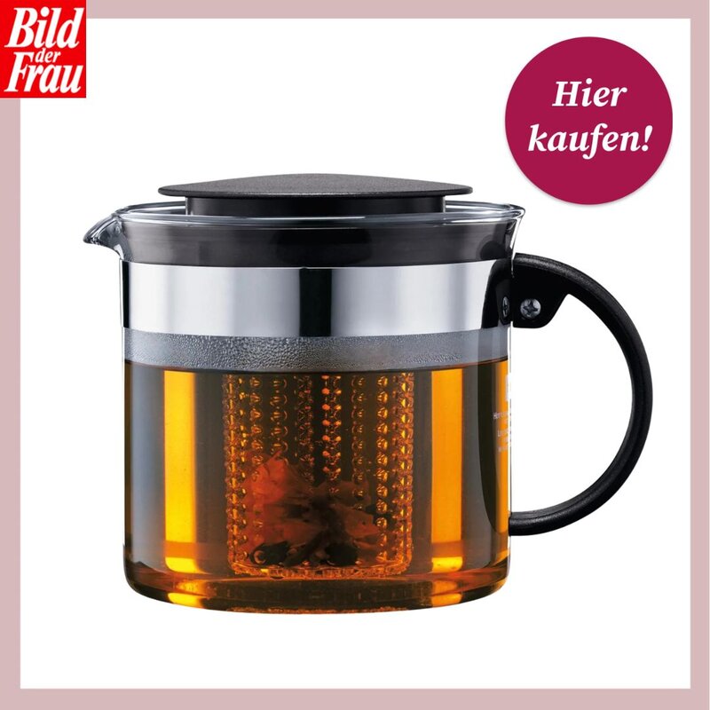 Eine gläserne Teekanne mit integriertem Teesieb, gefüllt mit bernsteinfarbenem Tee. Die Kanne hat einen schwarzen Griff und Deckel sowie eine silberne Metallmanschette. Oben links befindet sich das Logo von "Bild der Frau" und oben rechts ein runder, pinkfarbener Button mit der Aufschrift "Hier kaufen!". | © Lidl