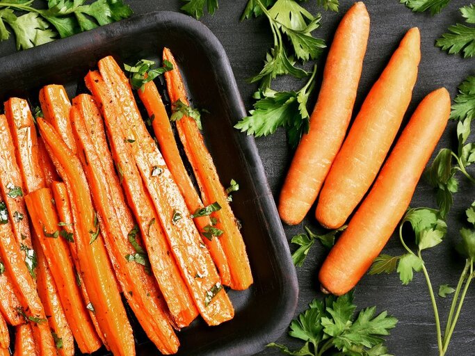 Blech mit Ofen-Karotten und rohe Karotten. | © Getty Images Pro/ Tatiana Volgutova via Canva.com