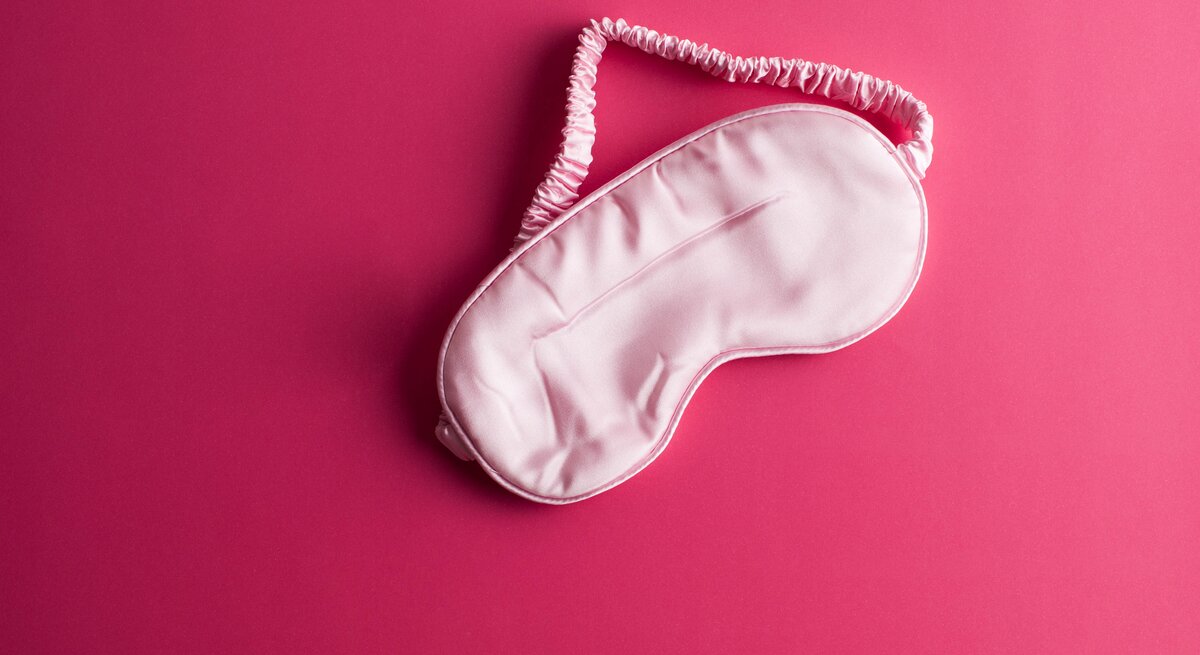 Schlafmaske auf rosa Untergrund.