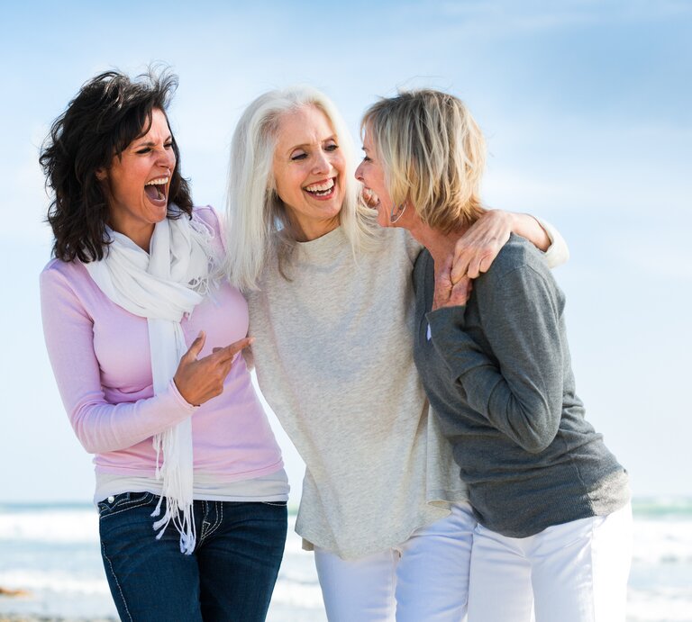Porträt von drei Frauen am Strand, die lachen und Spaß haben. | © getty images/AMR Image
