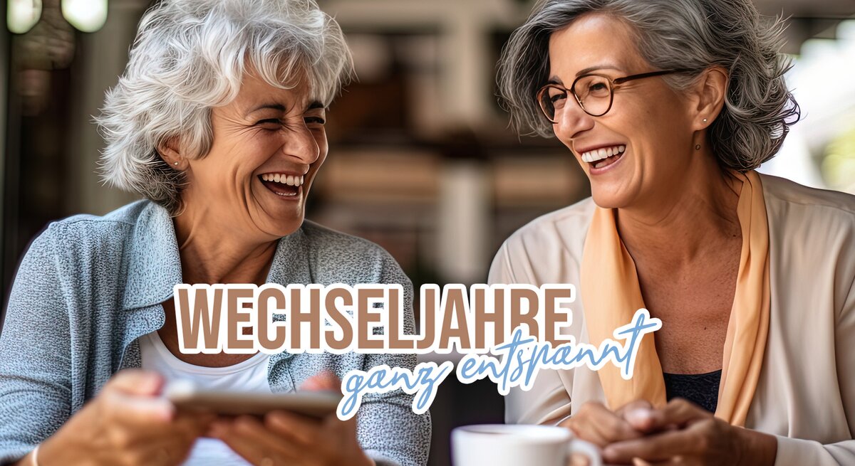 Zwei Frauen im höheren Alter sitzen lachend zusammen in einem Café.