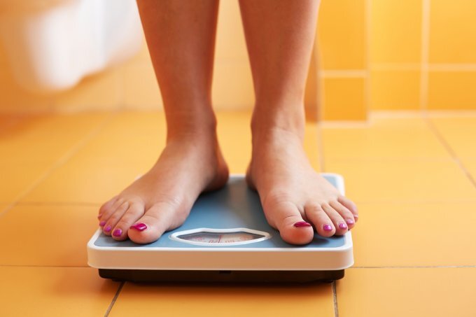 Eine Frau steht auf der Waage. | © © iStock/Rostislav_Sedlacek