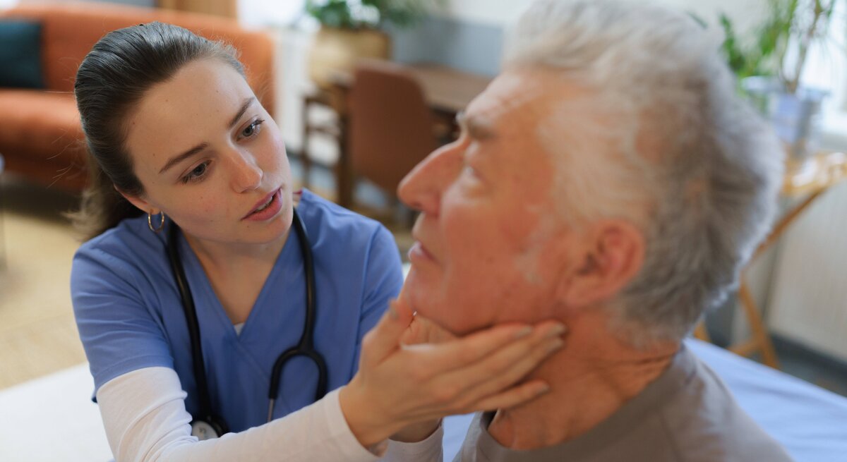 Eine Ärztin untersucht die Lymphknoten eines Patienten.