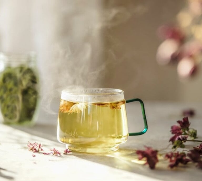 Frisch aufgebrühter Kräutertee in einer Glastasse auf dem Küchentisch. | © Getty Images/ Vicuschka