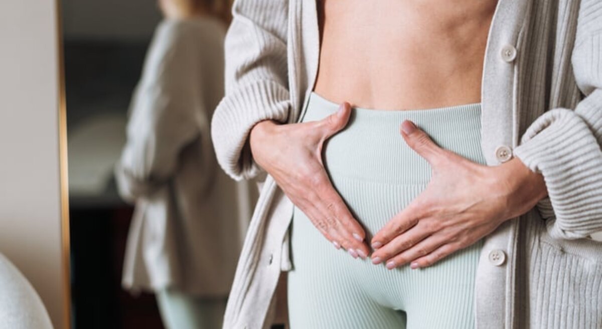Frau, die sich den Unterbauch hält.