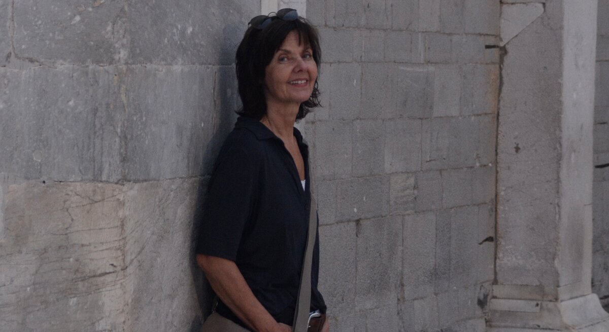 Zu sehen ist Claudia Tetling, die gegen eine Wand gelehnt steht.