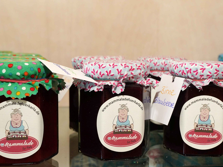 Sechs Gläser mit hausgemachter Marmelade, liebevoll verpackt mit bunten Stoffdeckeln und Etiketten mit Handschrift. | © GOLDENE BILD der FRAU