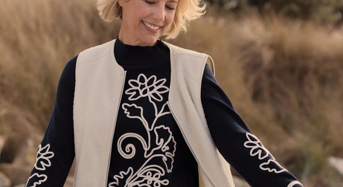 Zu sehen ist eine blonde Frau mit Bob mittleren Alters, die einen Pullover von Bonita trägt.