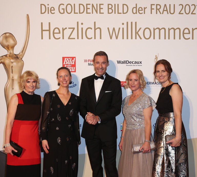 Kai Pflaume steht mit vier Frauen vor der Willkommenswand der GOLDENEN BILD der FRAU- Gala 2021  | © Stephan Wallocha