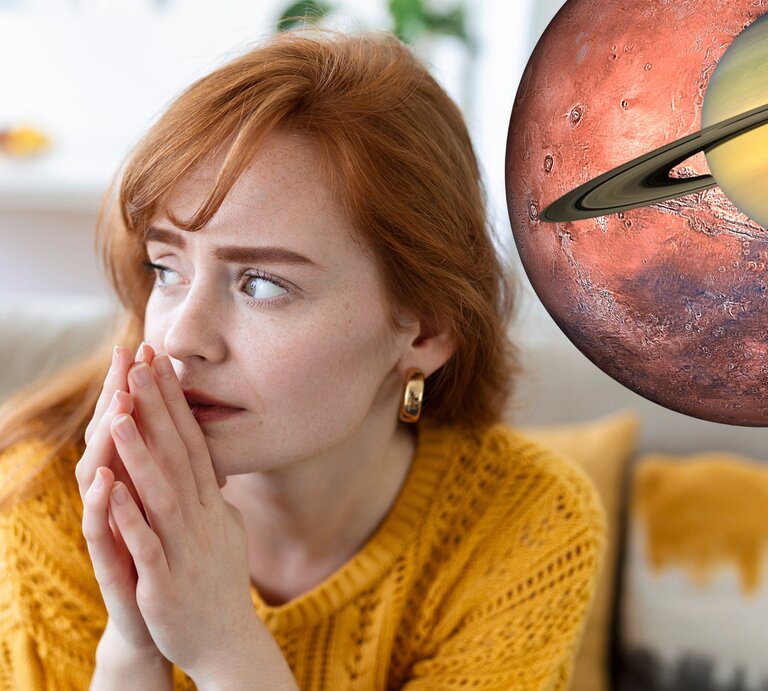 Eine besorgte rothaarige Frau in einem gelben Pullover sitzt drinnen, die Hände gefaltet, und schaut nachdenklich zur Seite. Direkt neben ihrem Kopf ist eine überdimensionale Darstellung des Planeten Mars mit dem Ring von Saturn montiert, als ob sie im Weltraum schweben und ein Fenster zur kosmischen Szene darstellen. | © Adobe Stock/ Graphicroyalty, Getty Images Signature/ BlackJack3D und Getty Images/LYagovy via Canva.com [M]