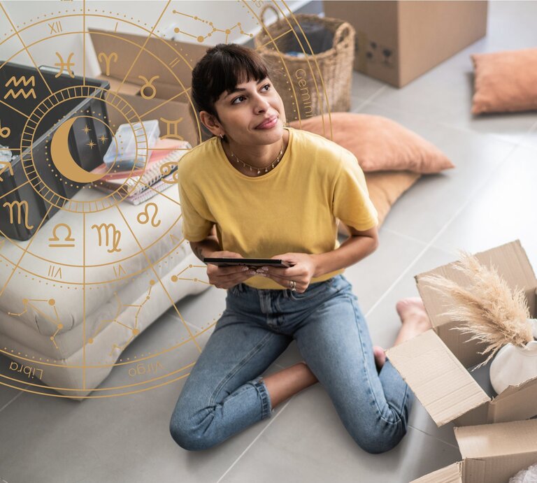 Eine Frau sitzt in ihrem Wohnzimmer inmitten von Umzugskartons. | © Getty Images/ FG Trade