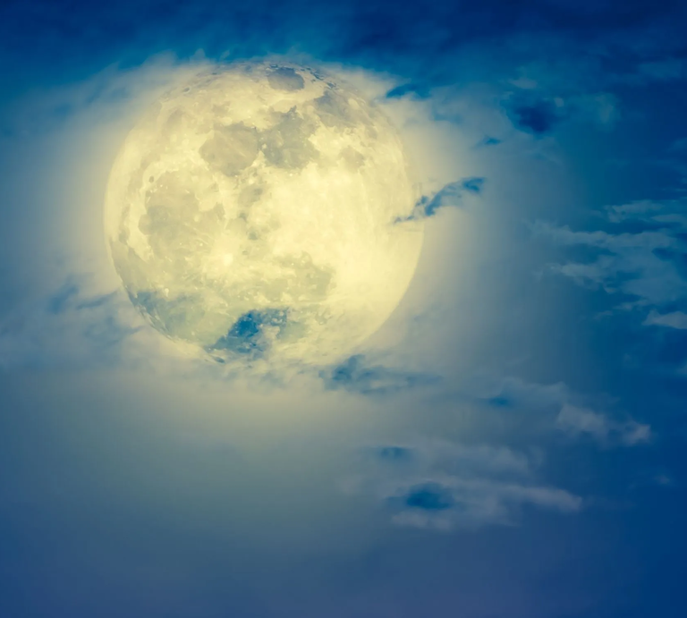 Mondhoroskop Oktober 2025: Heller Vollmond am Nachthimmel, umgeben von leicht ziehenden Wolken in Blau- und Weißtönen. | © Getty Images Pro/ kdshutterman