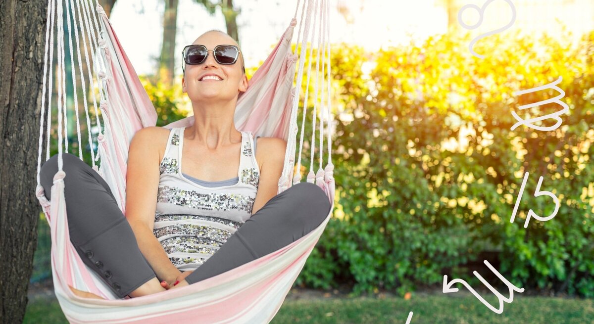Frau mit Sonnenbrille sitzt entspannt in einer Hängematte im Sonnenschein, lächelt zufrieden in den Himmel. Um sie herum schweben astrologische Tierkreiszeichen – Symbolbild für Erholung, Selbstfürsorge und astrologische Impulse im Monat Juni.