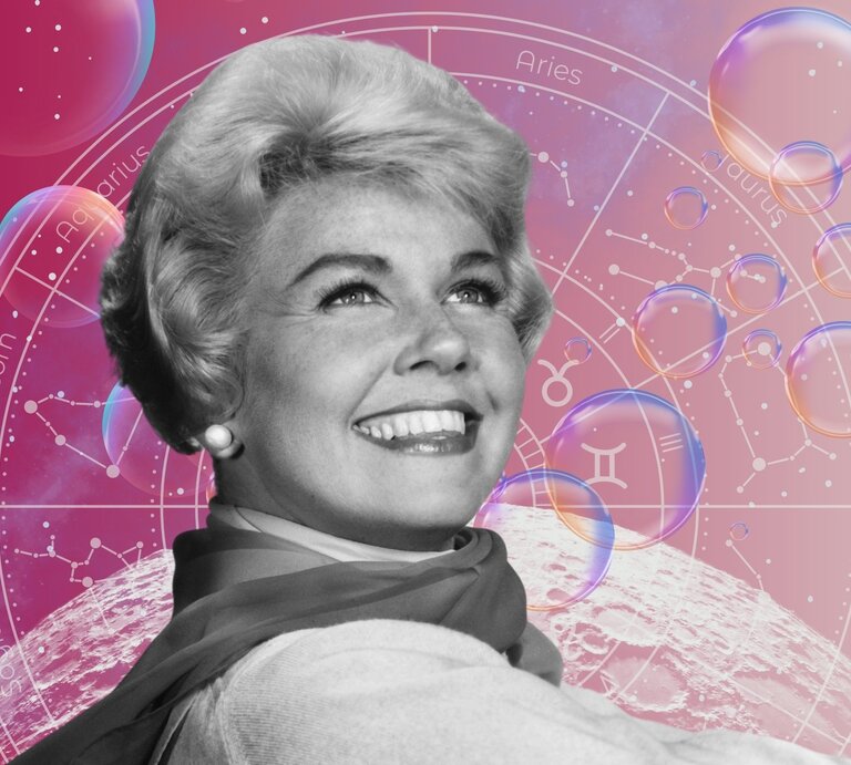 Die Schauspielerin Doris Day in schwarz-weiß steht strahlend vor einem Hintergrund, der das Universum und seine Sterne zeigt und einem Tierkreis mit den Symbolen der 12 Sternzeichen. Neben ihnen sind Seifenblasen zu sehen. Das Bild macht einen mystischen Eindruck. | © Getty Images/ Screen Archives , WinWin.artlab, Jaya Adi Prastya Design, kucingpink/ mohamad imron hamsyah und pixabay/ BestStock via Canva.com [M]