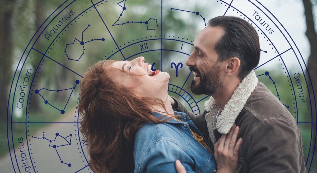 Ein lachendes Paar genießt einen romantischen Moment im Freien. Die Frau mit roten Haaren lehnt sich zurück, während der Mann sie sanft hält und beide sich strahlend ansehen. Im Hintergrund überlagert eine astrologische Tierkreisgrafik mit Sternzeichen und Konstellationen das Bild. Die Szene vermittelt Leichtigkeit, Spaß und eine verspielte, flirtende Energie, passend zum Thema Liebeshoroskop oder Flirtastrologie.