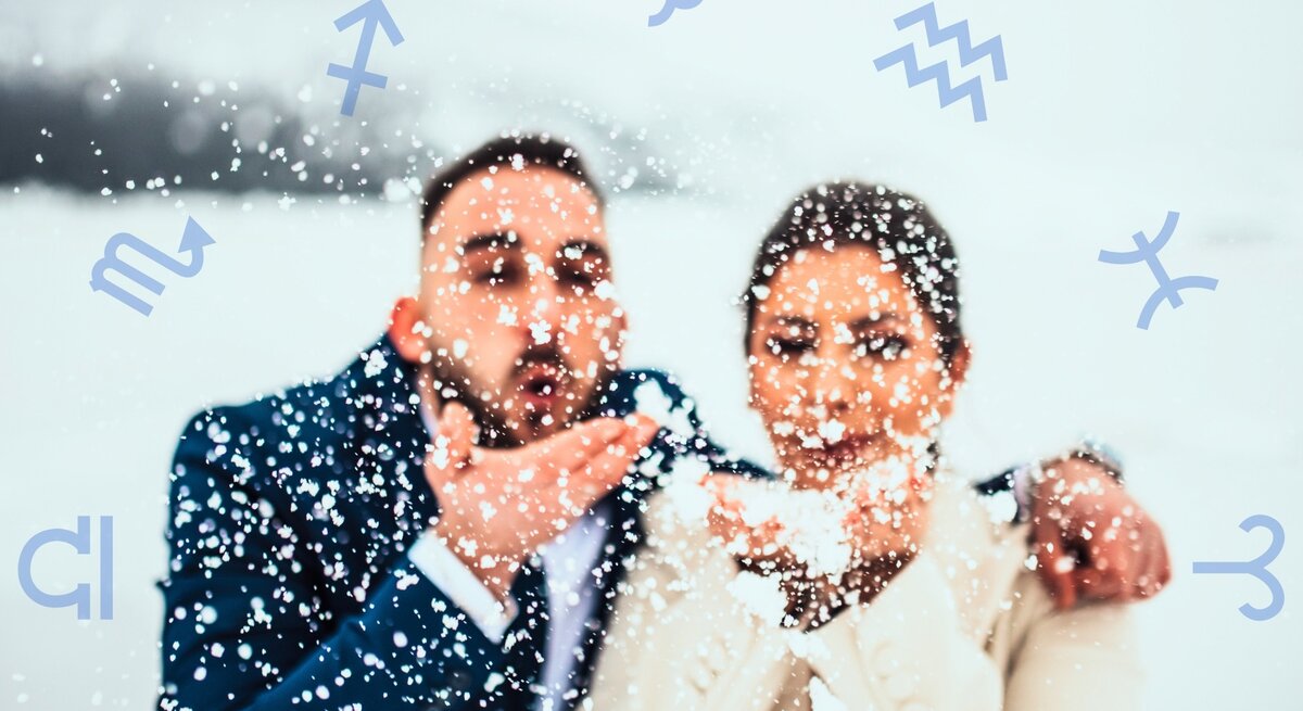 Ein fröhliches Paar in eleganter Winterkleidung steht in einer verschneiten Landschaft. Beide halten Schnee in ihren Händen und pusten ihn spielerisch in die Luft, wodurch Schneeflocken um sie herumwirbeln. Der Mann trägt einen dunkelblauen Anzug, die Frau einen cremefarbenen Mantel. Ihr Gesichtsausdruck strahlt Freude und Romantik aus. Im Hintergrund sind schneebedeckte Hügel und eine winterliche Landschaft zu erkennen. Um das Paar herum schweben verschiedene astrologische Symbole, darunter für Schütze, Skorpion, Wassermann und Fische, was eine Verbindung zur Astrologie und zu einem Flirthoroskop suggeriert.