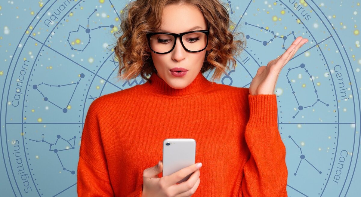  Eine junge Frau mit blonden, lockigen Haaren und einer schwarzen Brille hält ein Smartphone in der Hand und schaut überrascht oder nachdenklich darauf. Sie trägt einen leuchtend orangefarbenen Pullover. Im Hintergrund ist ein astrologisches Rad mit den Sternzeichen und funkelnden goldenen Details auf einem hellblauen Hintergrund zu sehen. Das Bild kombiniert moderne Technologie mit einem Hauch von Mystik und Astrologie und vermittelt eine dynamische, nachdenkliche Atmosphäre.