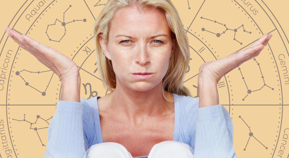 Eine blonde Frau mit ernstem und unzufriedenem Gesichtsausdruck sitzt mit angezogenen Knien und hebt beide Hände fragend oder ratlos nach oben. Sie trägt einen hellblauen Pullover. Im Hintergrund ist ein großes astrologisches Rad mit den Symbolen und Namen der Sternzeichen wie Aquarius, Taurus, Gemini und Capricorn zu sehen. Die warmen, gelblichen Farbtöne des Hintergrunds stehen im Kontrast zu ihrer angespannten Stimmung und vermitteln das Gefühl von Frustration oder Unsicherheit.