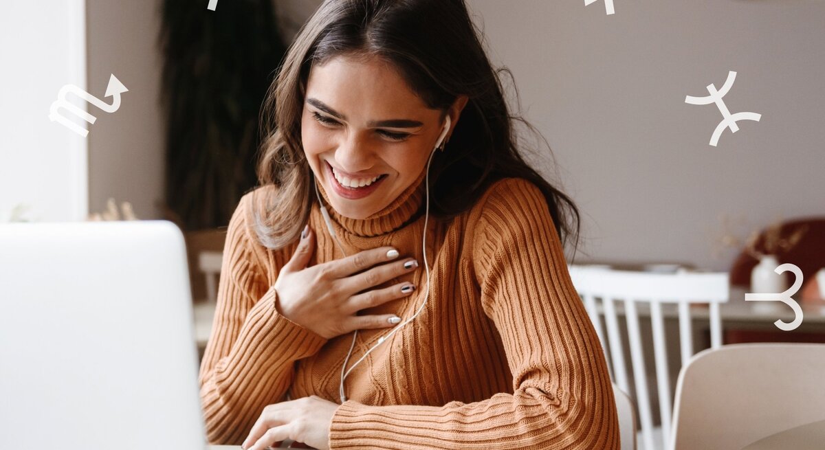 Junge Frau mit langen dunklen Haaren und einem braunen Strickpullover sitzt lächelnd vor einem Laptop. Sie trägt Kopfhörer und hält eine Hand freudig auf ihre Brust. Um sie herum sind weiße astrologische Sternzeichensymbole verteilt.