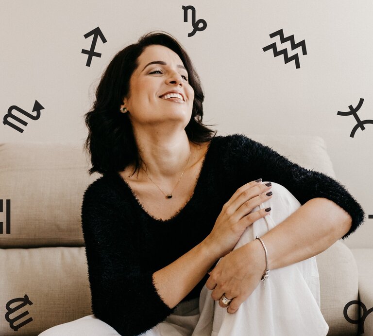 Eine Frau sitzt auf einem Sofa und blickt lachend nach oben. Sie sieht glücklich aus und ist umgeben von den astrologischen Symbolen der Tierkreiszeichen. | © Pexels/ Jonathan Borba und Chikovnaya via Canva.com [M]