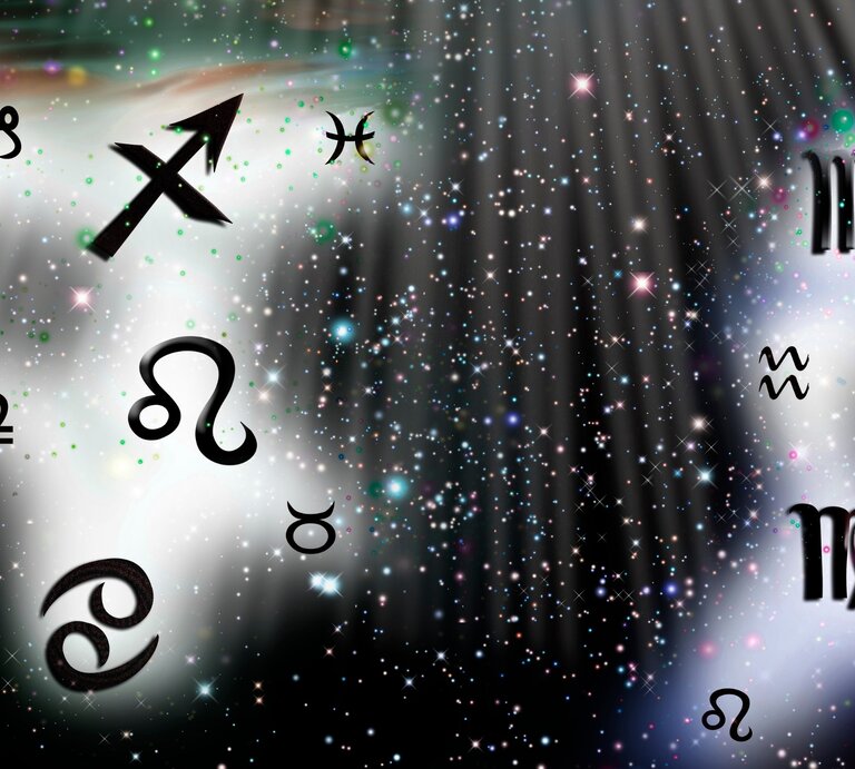 Dieses Bild zeigt eine Darstellung von Sternzeichen-Symbolen, die auf einem funkelnden, sternenartigen Hintergrund verteilt sind. Die Symbole, darunter Schütze, Fische, Jungfrau, Wassermann, Löwe, Waage, Krebs und Stier, sind in schwarzer Farbe gehalten. Der Hintergrund ist hell mit weißem Licht und strahlenden, bunten Partikeln sowie Sternen, die eine mystische und himmlische Atmosphäre erzeugen. Ein Lichtstrahl fällt von der oberen rechten Ecke herab und hebt einige der Symbole hervor. | © Getty Images/ Dzhulbee via Canva.com