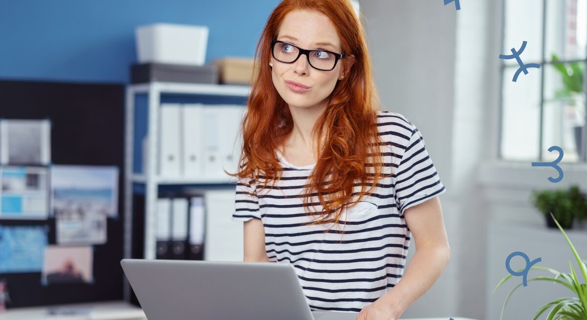 Eine nachdenklich blickende Frau mit rotem Haar und Brille sitzt in einem modernen Büro, während sie einen Laptop hält. Um sie herum sind astrologische Symbole zu sehen, was auf eine astrologische oder horoskopbezogene Arbeits- oder Lebenssituation hinweist.