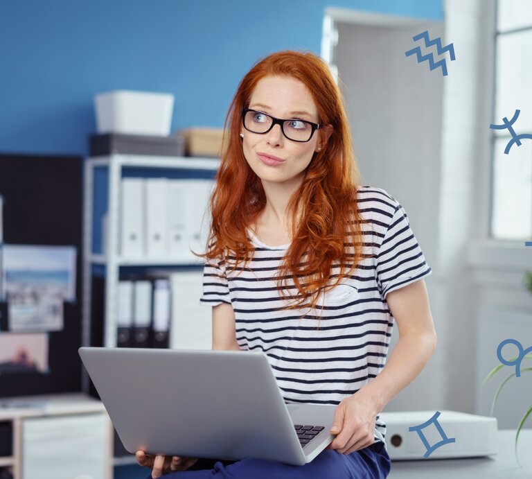 Eine nachdenklich blickende Frau mit rotem Haar und Brille sitzt in einem modernen Büro, während sie einen Laptop hält. Um sie herum sind astrologische Symbole zu sehen, was auf eine astrologische oder horoskopbezogene Arbeits- oder Lebenssituation hinweist. | © Adobe Stock/ contrastwerkstatt und Chikovnaya via Canva.com [M]