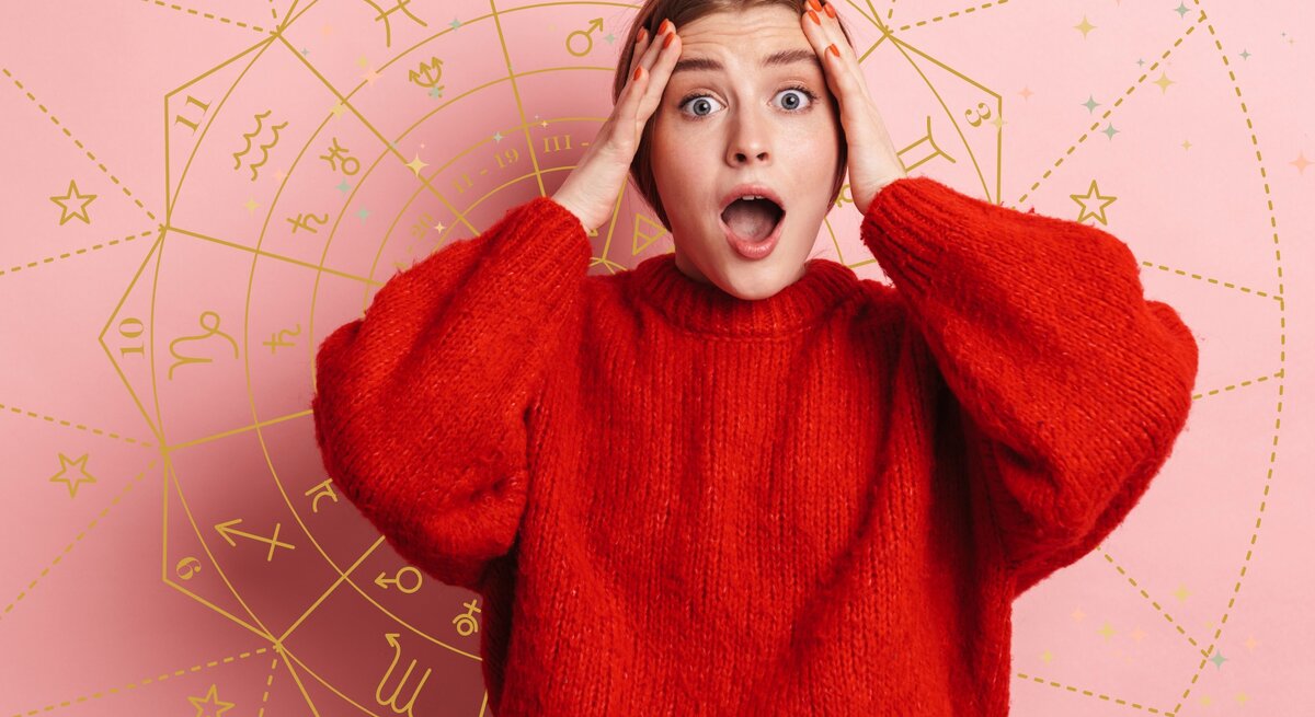 Das Bild zeigt eine überraschte oder erschrockene Frau, die beide Hände an ihren Kopf hält und den Mund weit geöffnet hat. Sie trägt einen roten Pullover und steht vor einem rosa Hintergrund, auf dem ein astrologisches Rad mit verschiedenen Sternzeichen-Symbolen abgebildet ist. Die Szene wirkt dramatisch und vermittelt den Eindruck, dass die Frau von einer unerwarteten Nachricht oder einer astrologischen Vorhersage überrascht ist. Das astrologische Rad im Hintergrund deutet darauf hin, dass es sich um ein Thema rund um Horoskope oder astrologische Ereignisse handelt.