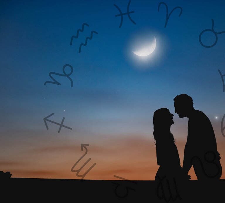 Ein Paar steht sich bei Sonnenuntergang gegenüber und schaut sich romantisch an, die Silhouetten sind vor einem farbenprächtigen Himmel mit einem leuchtenden Halbmond zu sehen. Um das Paar schweben astrologische Symbole der Tierkreiszeichen, die den Himmel zieren und einen mystischen, astrologischen Kontext schaffen. Der sanfte Übergang der Farben im Hintergrund, von Orange zu Blau, und die Verbindung zwischen den beiden Personen vermitteln eine stimmungsvolle, romantische Atmosphäre. | © Getty Images/ m-gucci und Keronyart's Images/ Be keronyart via Canva.com [M]