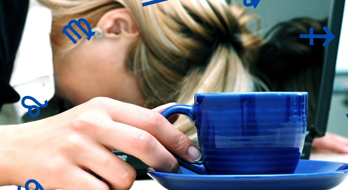 Das Bild zeigt eine erschöpfte Person, deren Kopf auf einem Tisch ruht, während sie eine blaue Tasse in der Hand hält. Im Hintergrund ist ein Laptop zu sehen, was darauf hindeutet, dass die Person möglicherweise überarbeitet ist oder eine Pause einlegt. Um die Person herum schweben verschiedene Sternzeichensymbole, was darauf hindeutet, dass der Artikel wahrscheinlich das Thema Astrologie behandelt und möglicherweise die Auswirkungen der Sternzeichen auf das Wohlbefinden oder die Stressbewältigung im Fokus hat.