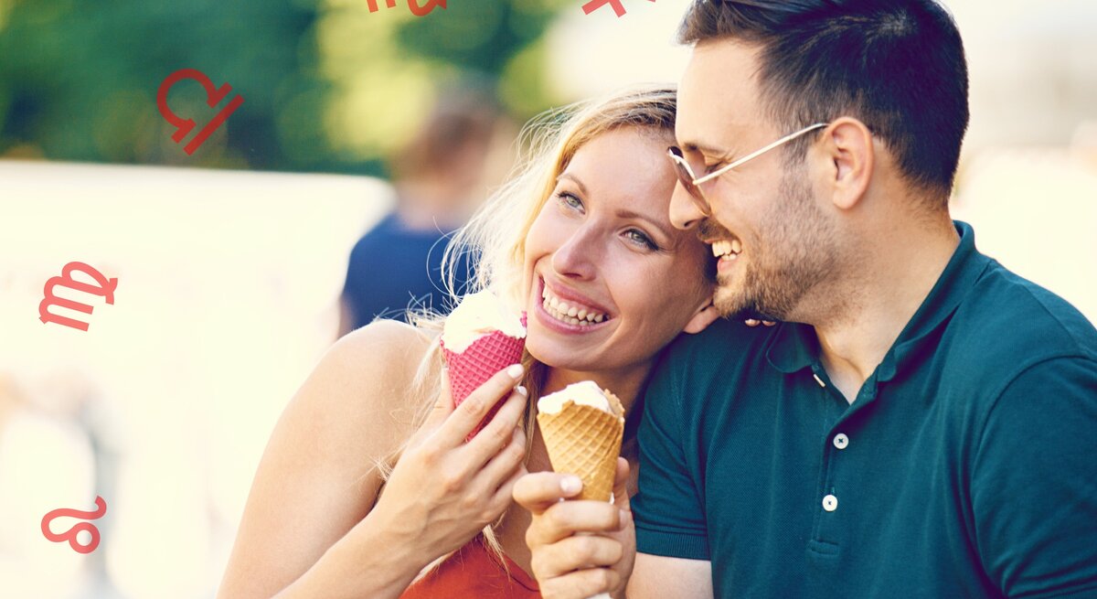 Ein lächelndes Paar genießt Eiscreme im Freien. Die Frau trägt ein orangefarbenes Oberteil und hält ein Eis mit einem rosa Waffelhörnchen, während der Mann ein grünes Poloshirt trägt und ein Eis mit einem braunen Waffelhörnchen hält. Um sie herum sind verschiedene Sternzeichen-Symbole zu sehen, darunter Löwe, Jungfrau, Waage, Skorpion und Schütze. Die Stimmung ist entspannt und fröhlich.