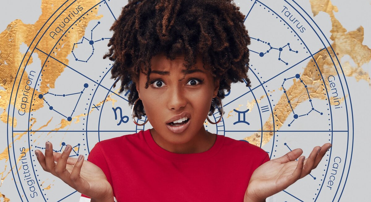 Eine junge Frau mit dunklen lockigen Haaren und einem roten T-Shirt hebt verwirrt beide Hände und blickt mit einem erstaunten Gesichtsausdruck in die Kamera. Im Hintergrund befindet sich ein astrologischer Kreis mit den Symbolen und Konstellationen der zwölf Tierkreiszeichen in Blau auf einem grauen Hintergrund, verziert mit goldenen Akzenten.
