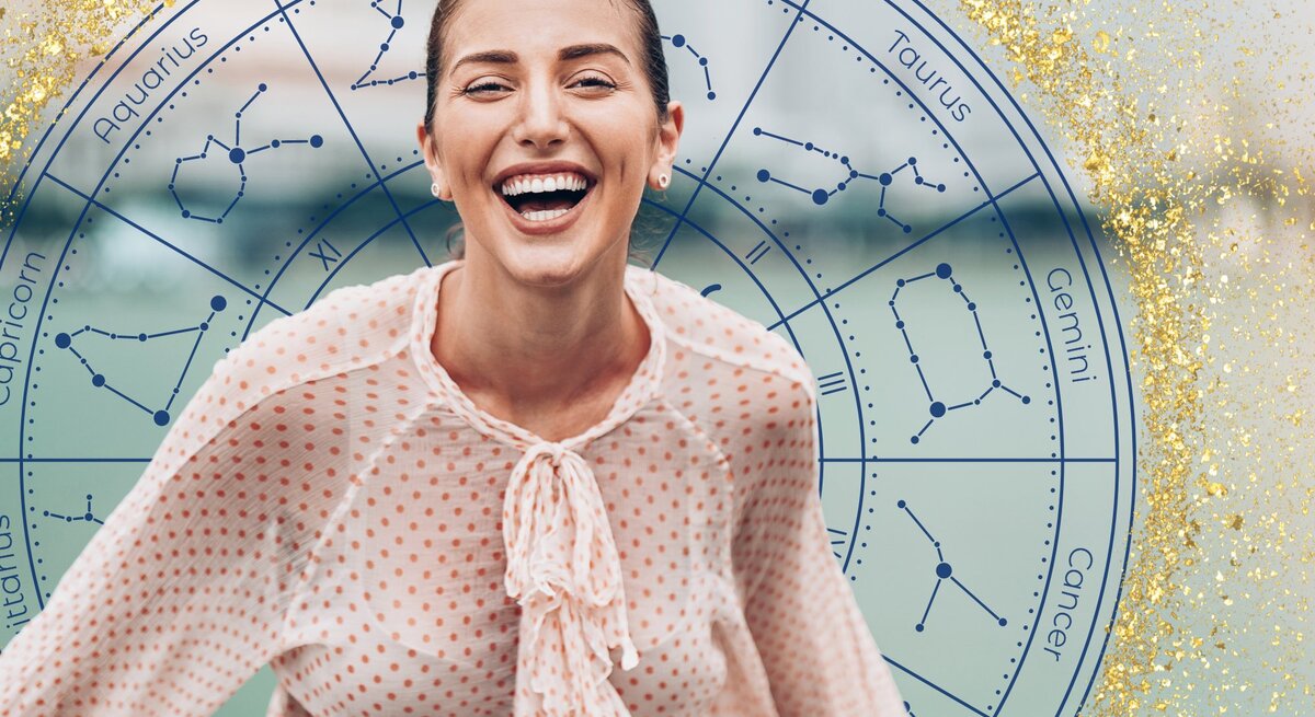 Eine lachende Frau mit zurückgebundenem Haar trägt eine gepunktete Bluse und steht vor einem astrologischen Kreis, der die Symbole und Konstellationen der zwölf Tierkreiszeichen zeigt. Der Hintergrund ist mit goldenen Glitzereffekten verziert, was die fröhliche und optimistische Stimmung des Bildes unterstreicht.