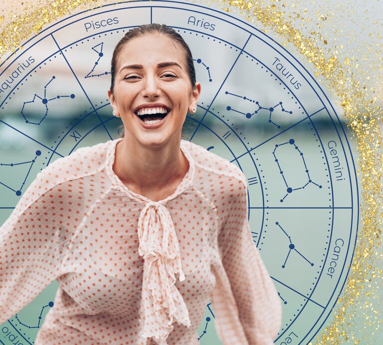 Eine lachende Frau mit zurückgebundenem Haar trägt eine gepunktete Bluse und steht vor einem astrologischen Kreis, der die Symbole und Konstellationen der zwölf Tierkreiszeichen zeigt. Der Hintergrund ist mit goldenen Glitzereffekten verziert, was die fröhliche und optimistische Stimmung des Bildes unterstreicht. | © Getty Images Signature/ pixelfit, JMBee Studio und WinWin.artlab via Canva.com [M]