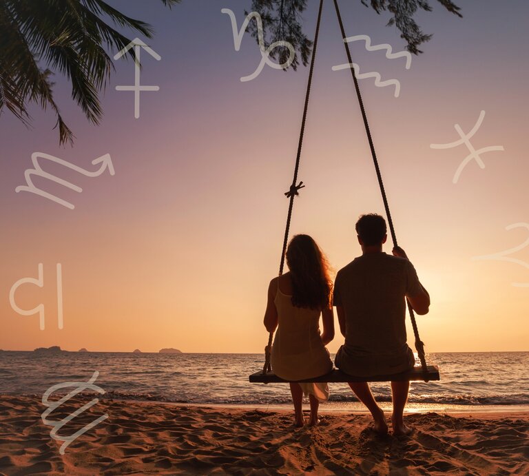 Ein Paar sitzt zusammen auf einer Schaukel am Strand und schaut in den Sonnenuntergang. Der Himmel ist in warmen Orange- und Rosatönen gefärbt. Um das Bild herum sind verschiedene Sternzeichen-Symbole verteilt, die eine astrologische Verbindung andeuten. Eine Palme ragt von oben ins Bild, was die tropische Atmosphäre verstärkt. Die Szene strahlt Ruhe, Romantik und Verbundenheit aus. | © Adobe Stock/ Song_about_summer und Keronyart's Images/ Be keronyart via Canva.com [M]