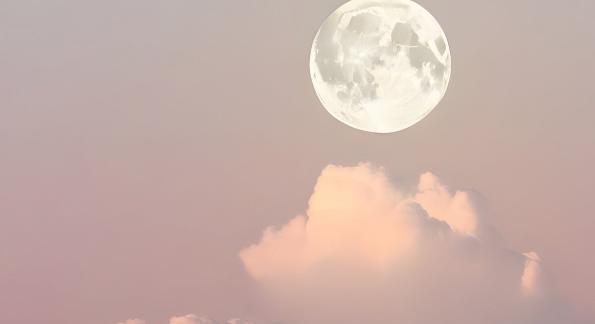 Das Bild zeigt den Vollmond, der am Himmel über pastellfarbenen Wolken schwebt. Der Himmel hat eine weiche Farbpalette aus Rosa und Lavendel, die eine friedliche und ruhige Atmosphäre schafft. Der Mond ist klar und detailreich sichtbar, und die Wolken darunter erscheinen flauschig und leicht, was dem Bild einen träumerischen Charakter verleiht.