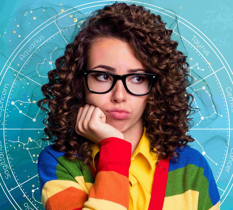 Nachdenkliche Frau mit lockigem Haar und bunter Strickjacke, umgeben von astrologischen Symbolen und Sternbildern vor einem blauen Hintergrund. | © Deagreez/Gettyimages, sinedigitaldesigns, veronika-oliinyks-images via Canva.com [M]