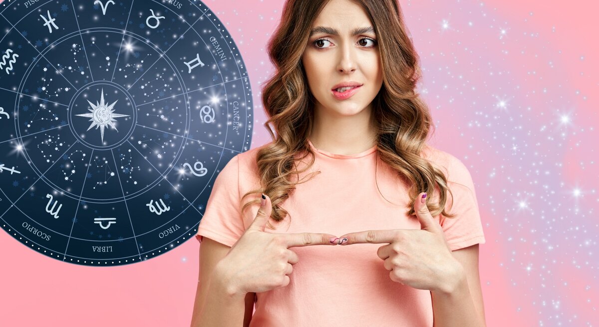 Ein verwirrter Ausdruck zeigt sich auf dem Gesicht einer jungen Frau mit lockigen braunen Haaren und einem rosa T-Shirt, die ihre Zeigefinger nach innen auf sich selbst richtet. Im Hintergrund ist ein großes Astrologie-Rad mit den Symbolen der Tierkreiszeichen zu sehen. Der gesamte Hintergrund schimmert in Rosa mit funkelnden Sternen, was den Eindruck einer Verbindung zwischen der Frau und den Sternzeichen verstärkt.