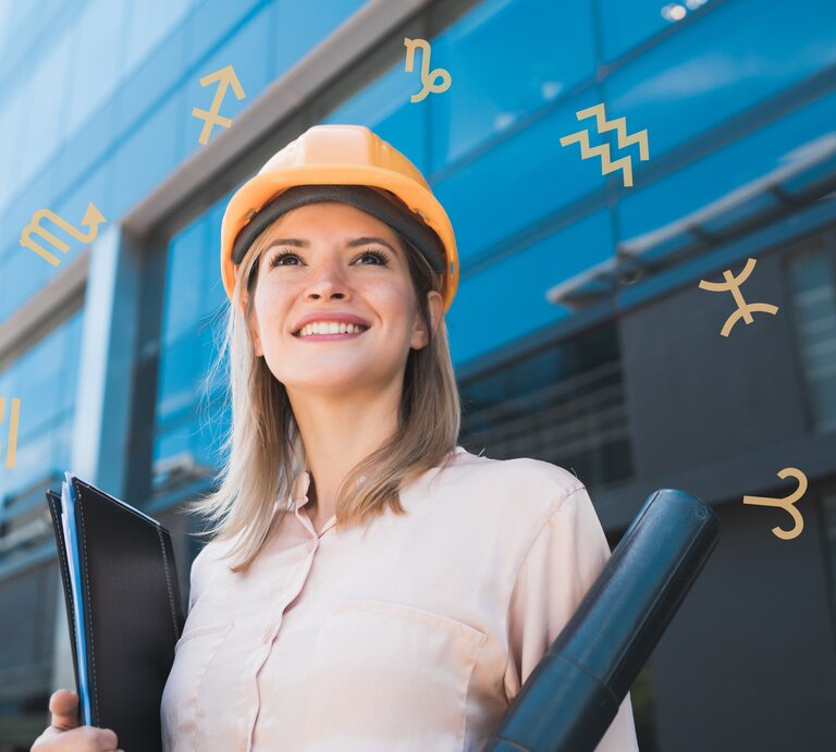 Eine Frau in einer weißen Bluse steht vor einem Bürogebäude mit Glasfassade und trägt einen gelben Bauarbeiterhelm. Umgeben ist sie von einem Kreis der astrologischen Symbole der Sternezichen. | © Adobe Stock/ Mego-studio und Chikovnaya via Canva.com [M]