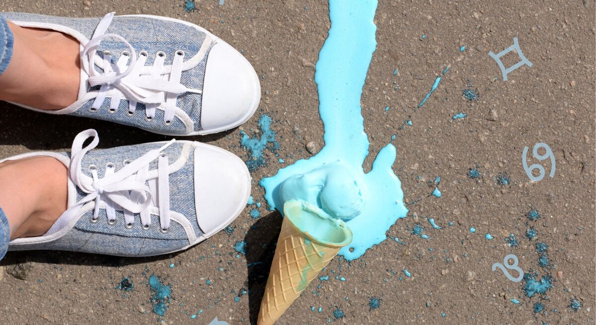 Neben ein paar Chucks liegt ein türkisfarbenes Eis auf der Straße.