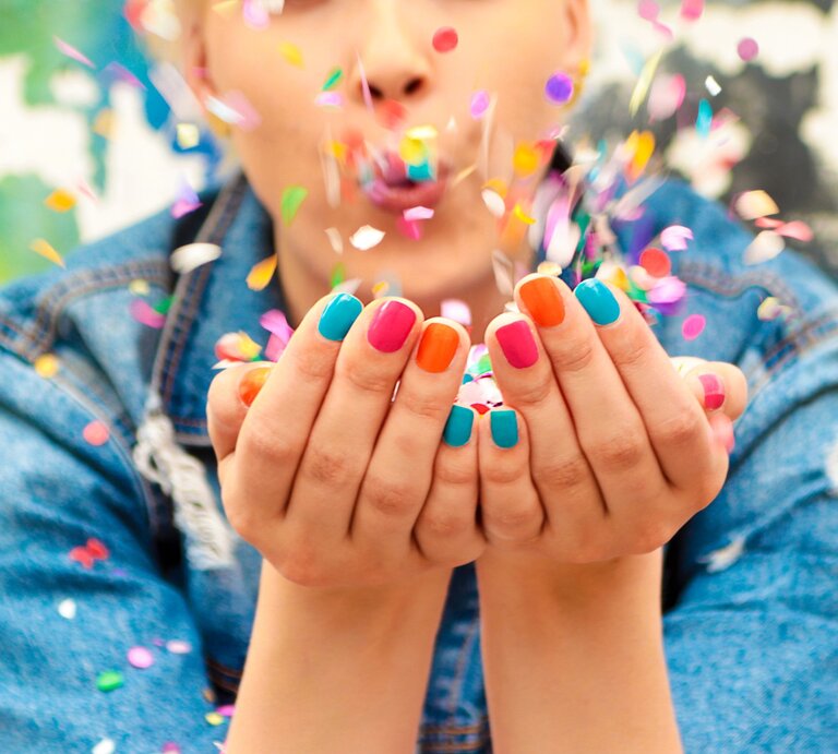 Eine Frau bläst Konfetti aus ihrer Hand. | © Adobe Stock/ marigo
