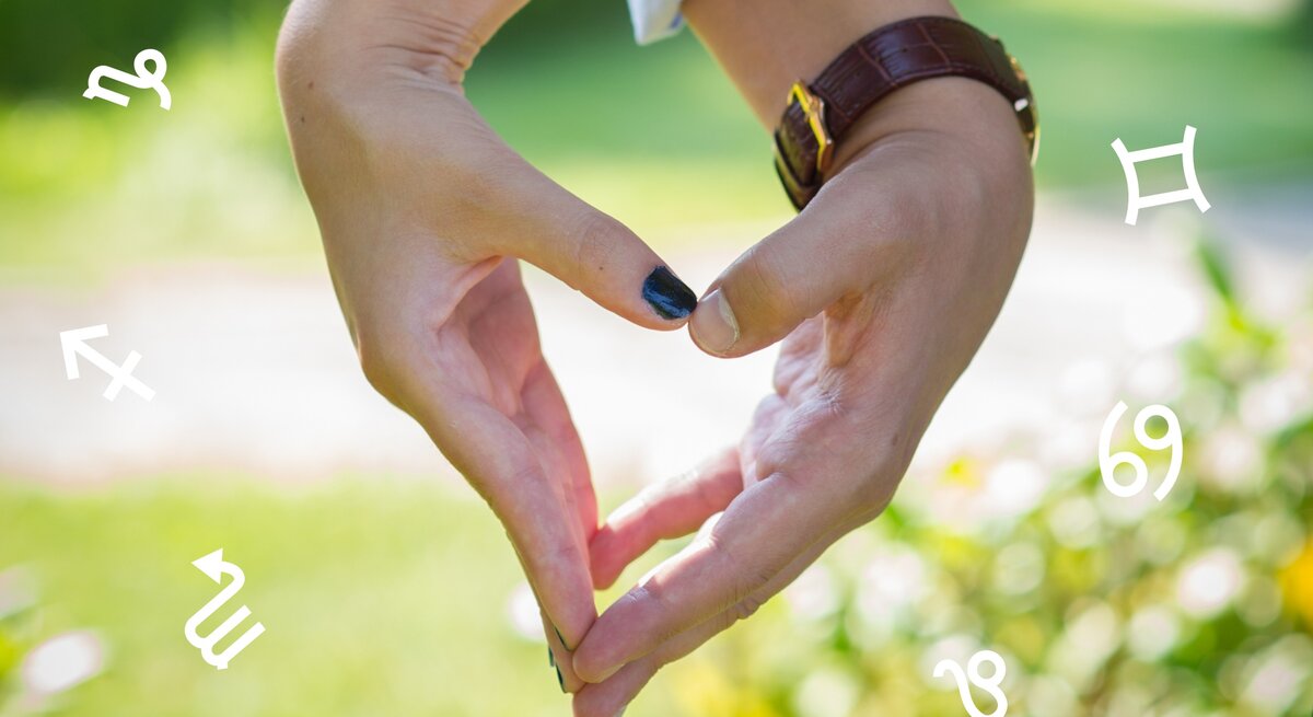 Die Hand einer Frau und eines Mannes formen ein Herz. Im Hintergrund ist das Grün von Natur zu sehen. Umgeben sind die Hände von den astrologischen Zeichen des Tierkreises. 