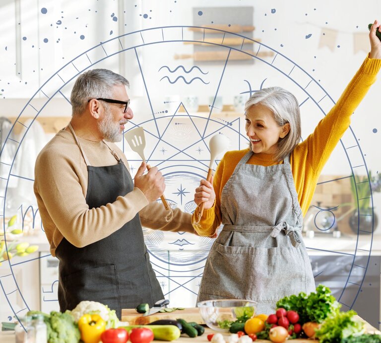 Ein Paar tanzt und hat Spaß in der Küche und nutzt Kochlöffel als Mikrofone. Im Hintergrund ist der Tierkreis mit den astrologischen Symbolen der Sternzeichen zu sehen.  | © Adobe Stock/ JenkoAtaman und Chikovnaya via Canva.com [M]