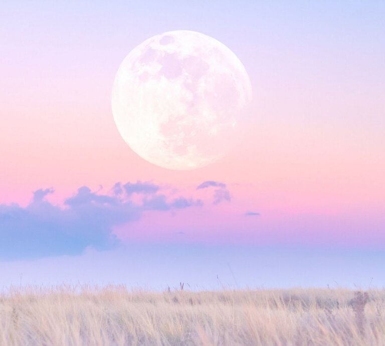 Großer Vollmond über einem pastellrosa‑violetten Himmel mit zarten Wolken; im Vordergrund eine helle, trockene Wiese/Steppe in weichem Abendlicht. | © TrueCreatives via Canva.com