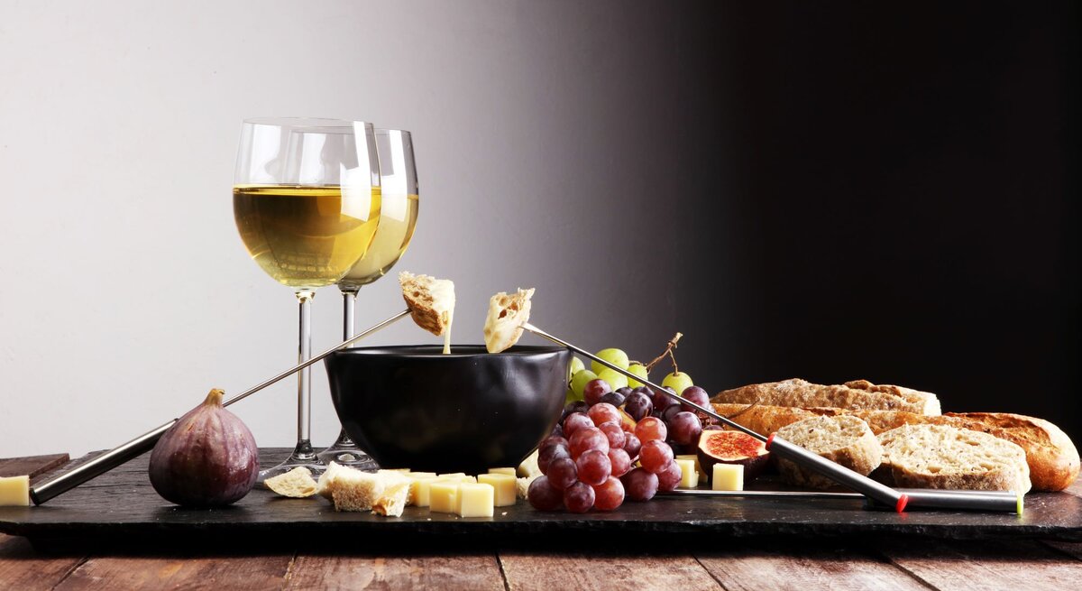 Ein Käsefondue mit zwei Gläsern Wein.