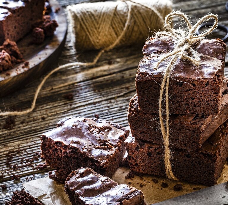 Klassische Brownies, mal einzeln, mal gestapelt / Untergrund grobes Holz /  Messer aus Metall / Kuchengitter /  | © Gettsy Images / fcafotodigital