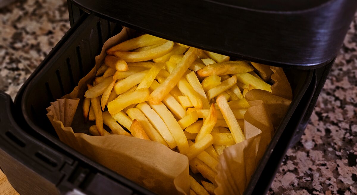 Eine Heißluftfritteuse mit Pommes. 