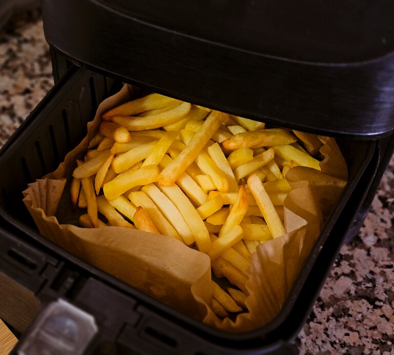 Eine Heißluftfritteuse mit Pommes.  | © AdobeStock/Elena Uve
